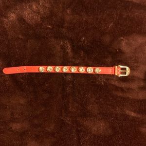 Henri Bendel orange leather wrist strap with large stones studs bright stones